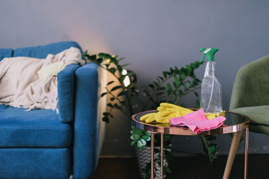 Gloves and a spray bottle on a table in a living room
